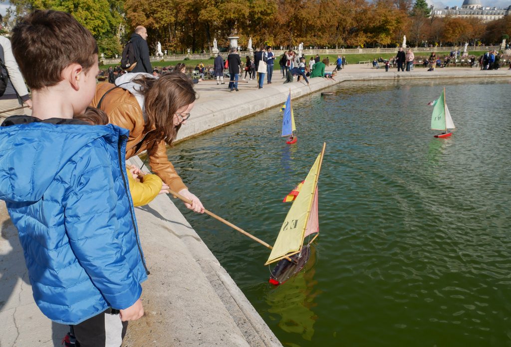 Sailing wooden boats in Luxembourg Gardens Paris with children.s 